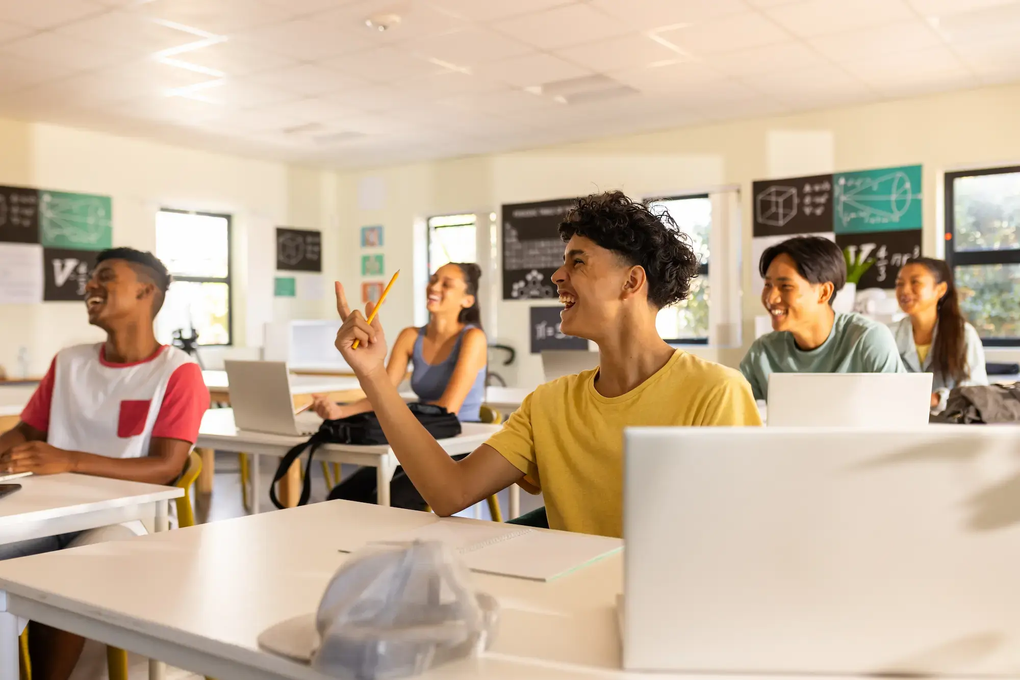 high-school-teenagers-using-laptops-raising-hands-classroom-discussion